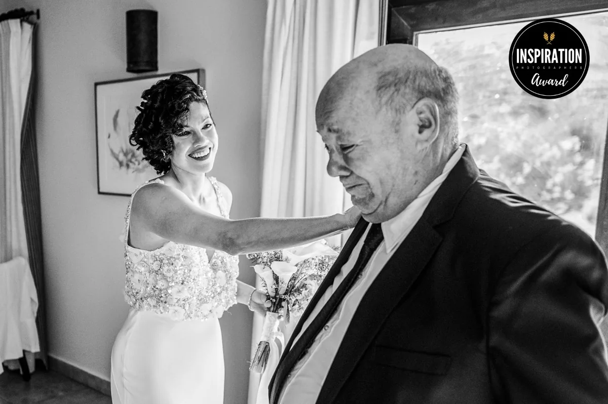 Novia sonriendo mientras su padre se emociona al verla vestida de novia en Piattelli, Cafayate. Foto de Agustín Fernández Savoy premiada por Inspiration Photographers
